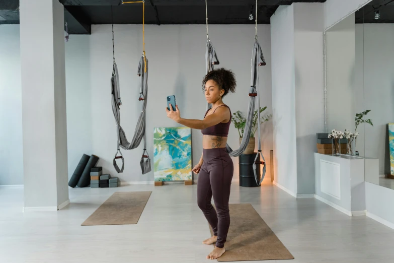 a woman uses a hanging device to use in a yoga class