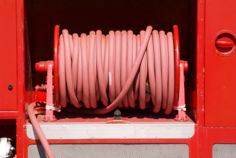 a pink hose is attached to the back of a red truck