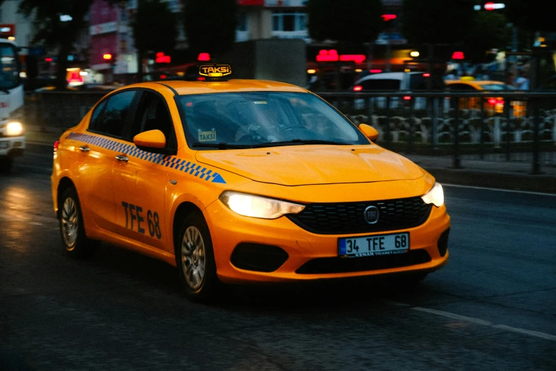 a taxi cab is driving down the road at night