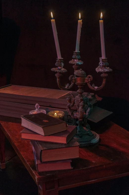 books are stacked with candles on a table