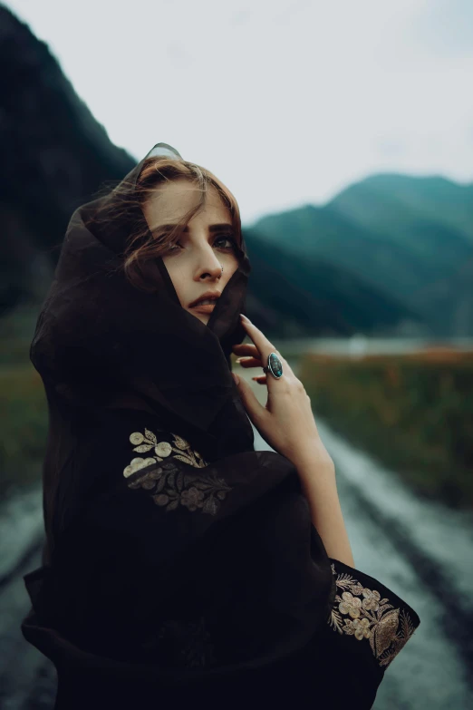 a woman in black in the country posing for the camera