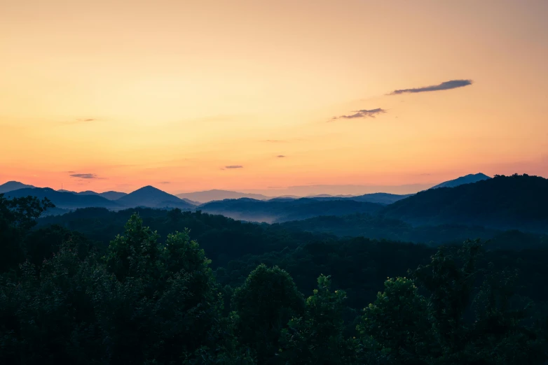 the sun is setting over a beautiful valley and trees