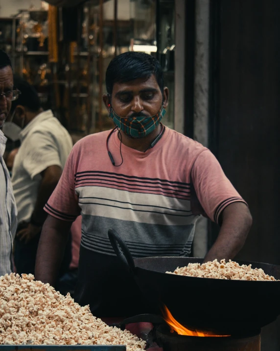 a man with a surgical mask on cooking food