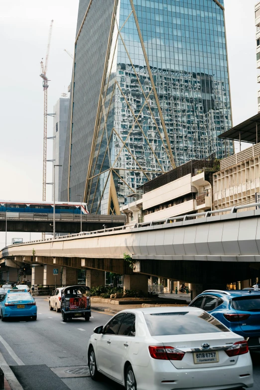 vehicles move on the busy highway as a train passes