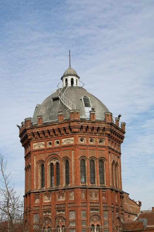 a large red brick building has a clock on top