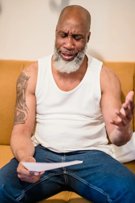 a man sitting on a couch with a white mustache