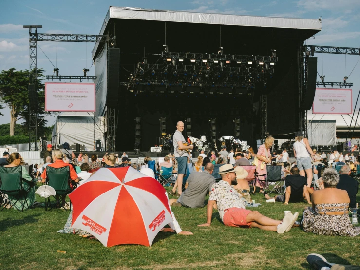 there are several people on the grass at an outdoor concert