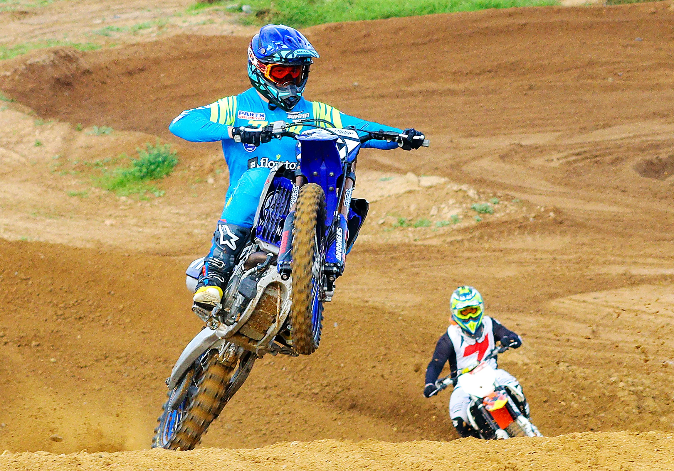two people on bikes riding the dirt near each other