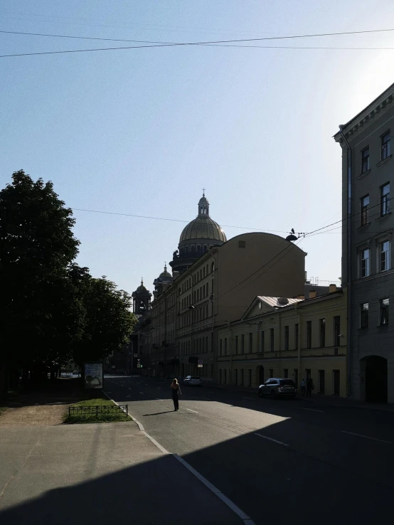 a large building next to two buildings with a dome in the background