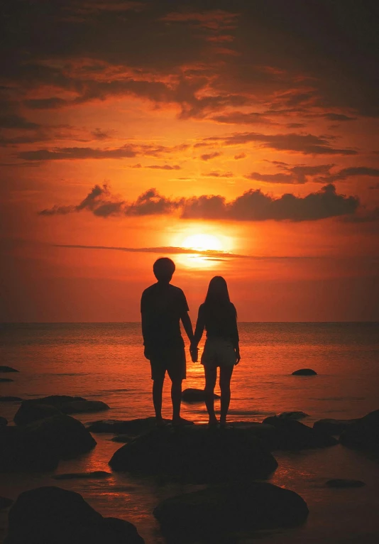 a couple of people standing in the water holding hands