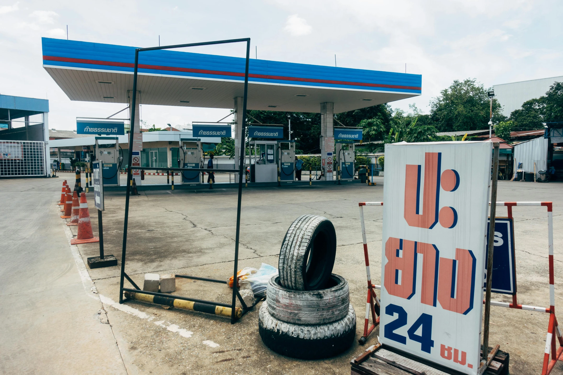 a pile of tires sitting on the side of a gas station