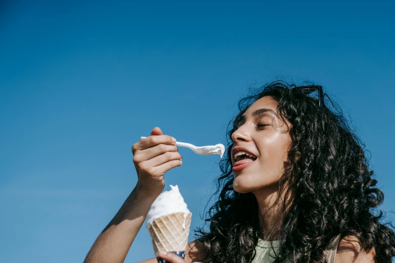 a beautiful woman holding up an ice cream cone