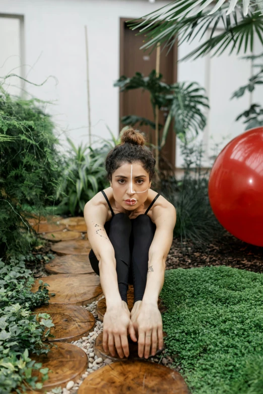 the woman is sitting down in the green yard