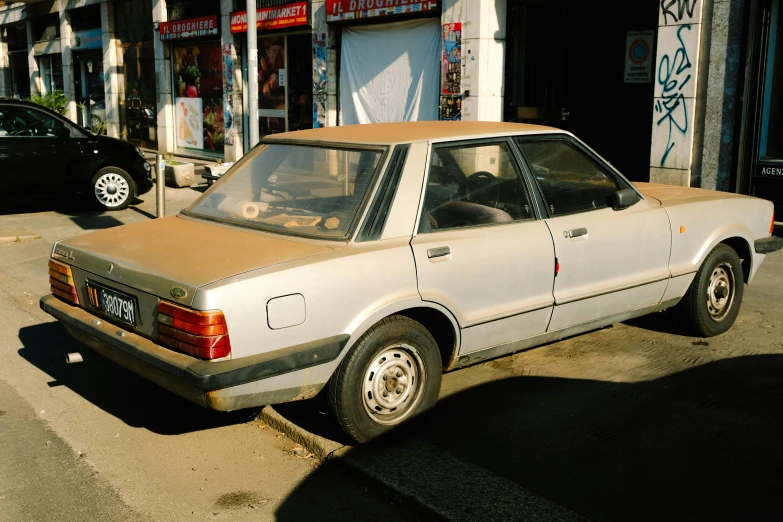 a beige car that is sitting in the street