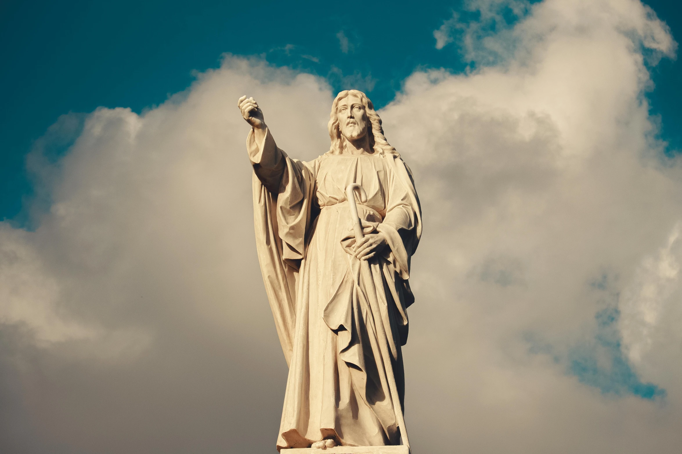 statue of mary holding a cup in the air