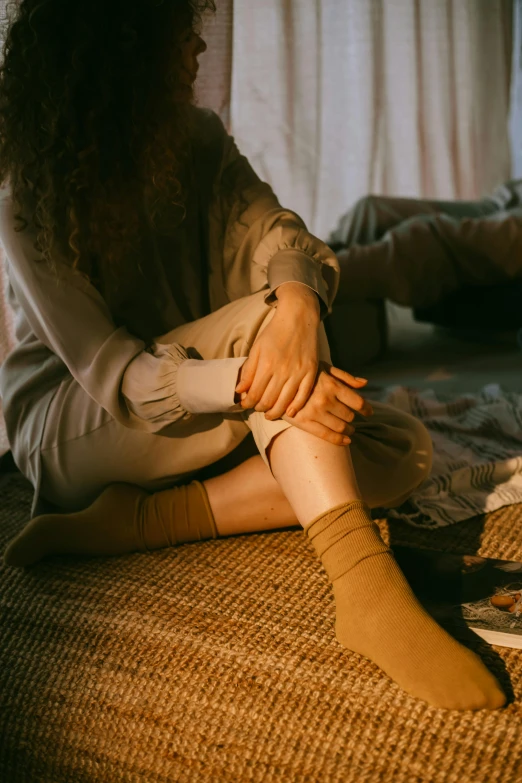 a person sitting on the floor with socks around their ankles