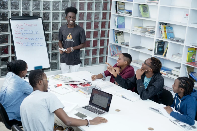 a group of young people sitting around a table talking