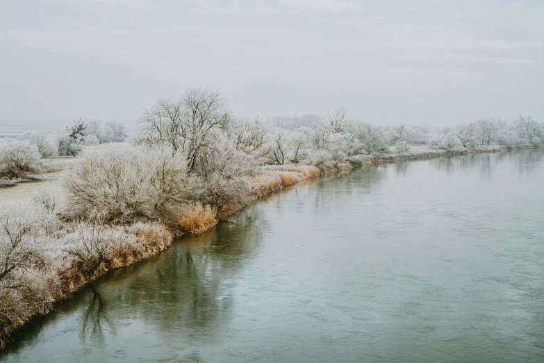 a calm, snowy river on an icy winter day