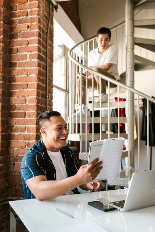 a man sitting at a desk next to a laptop