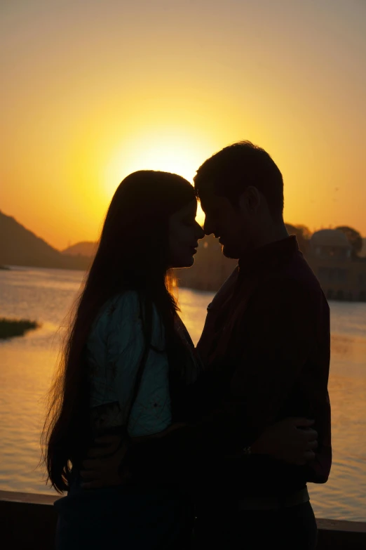 a man and woman in silhouette at sunset