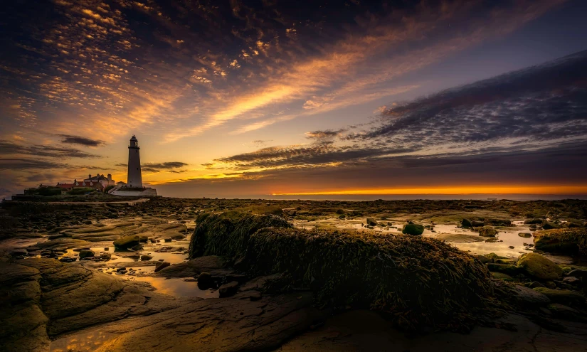 a po taken from a beach at sunset in front of a lighthouse