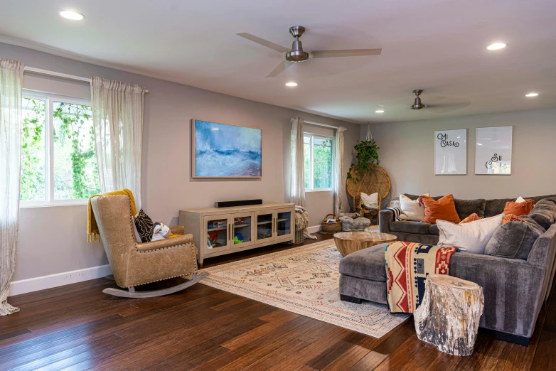 a room with couches, chairs, and a rug in it