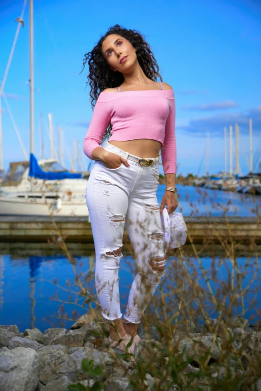 a beautiful young woman standing next to water