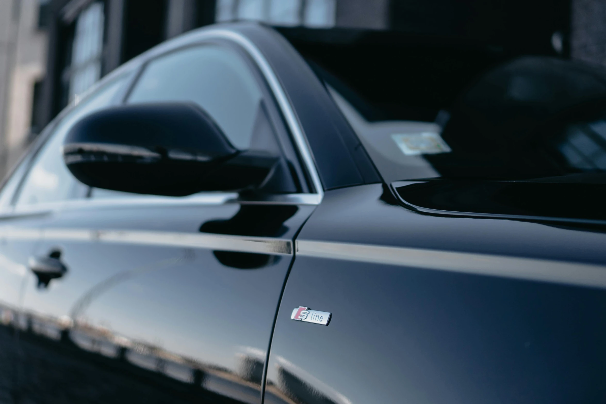 a side mirror view of a shiny black car