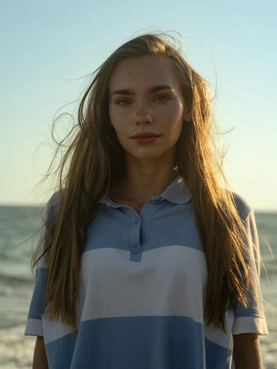 a woman poses in front of the ocean