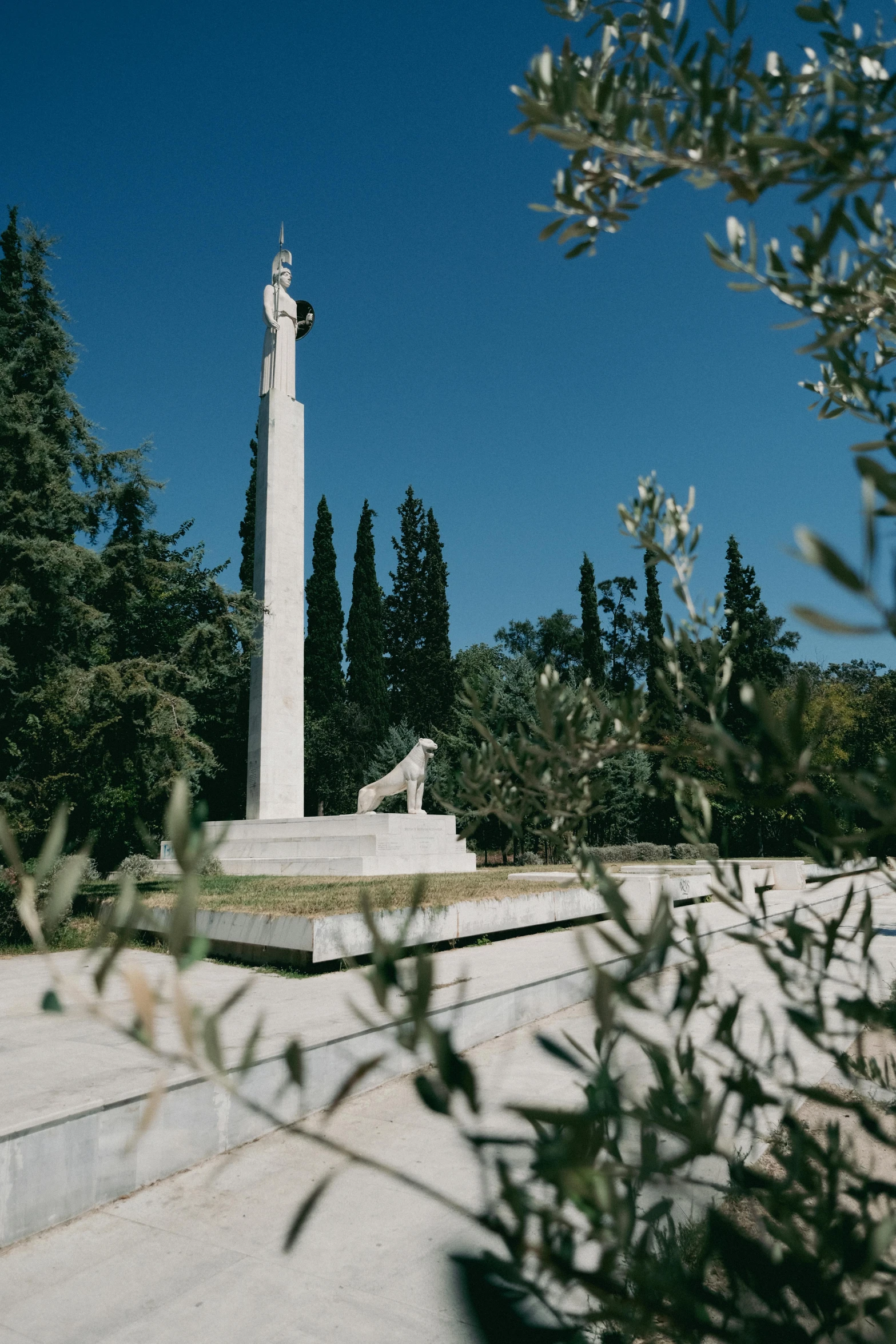 a white monument surrounded by trees and shrubs