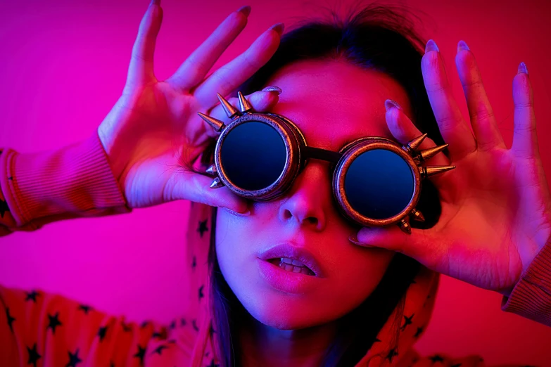 a woman looking through two circular metal glasses