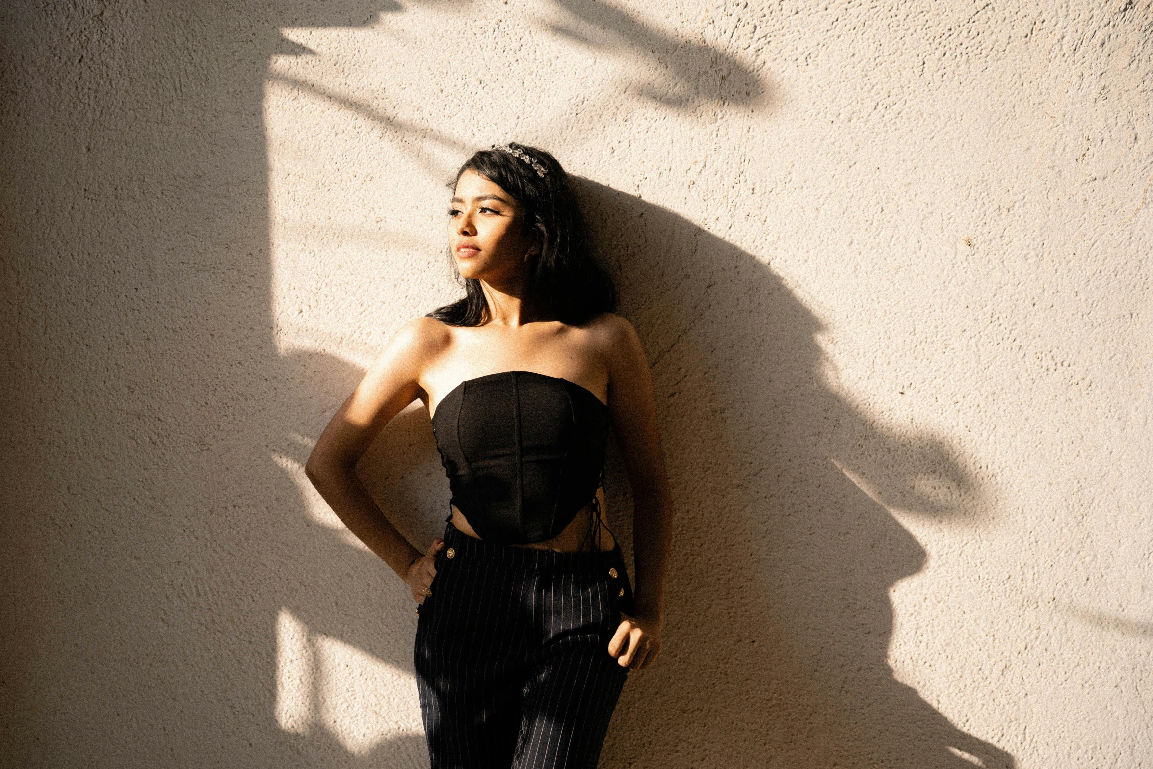 a woman standing in front of a wall posing for a picture