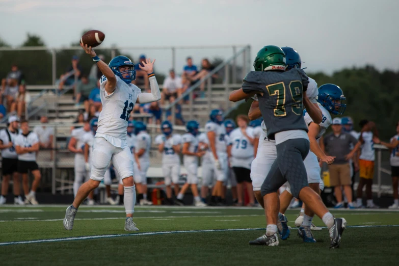 football players in blue and white uniforms holding up a ball