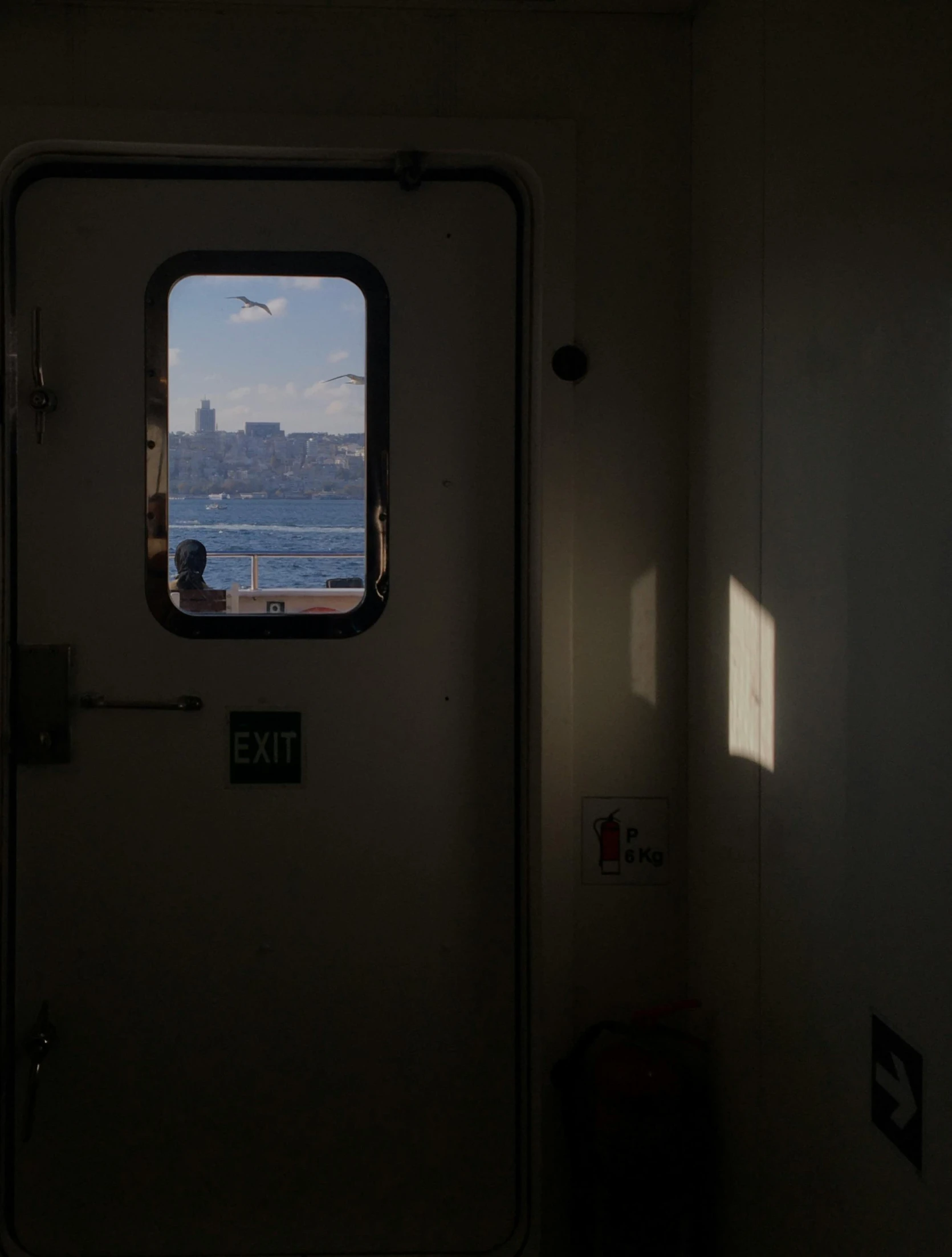 the view out of a small door of a ferry on the water