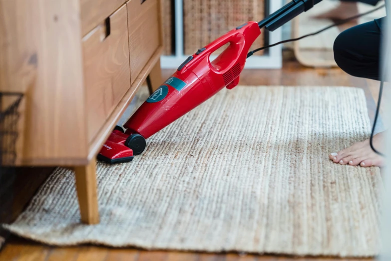 someone using a vacuum cleaner to clean carpet