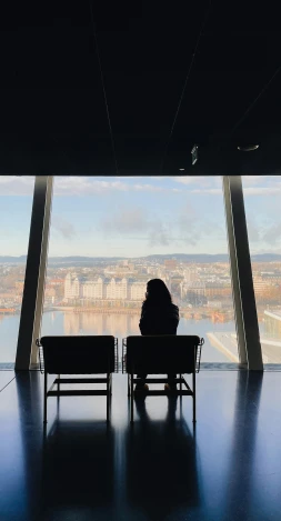a person sitting in a chair looking out over a city