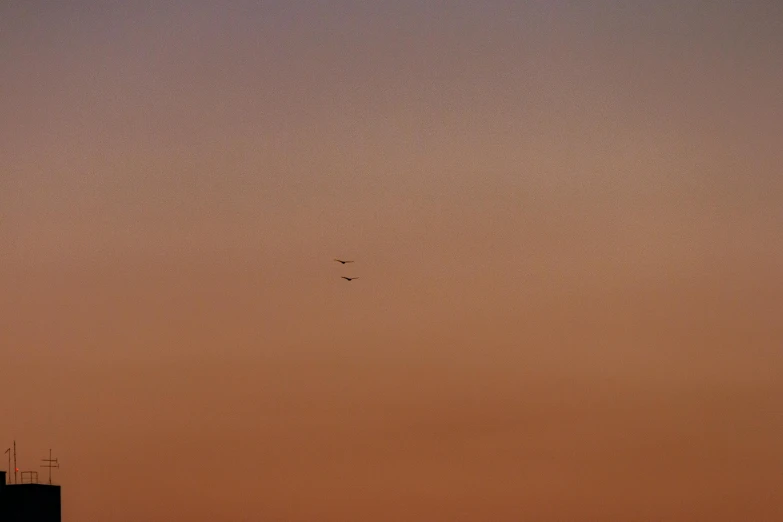 an airplane is flying in the sky near a building