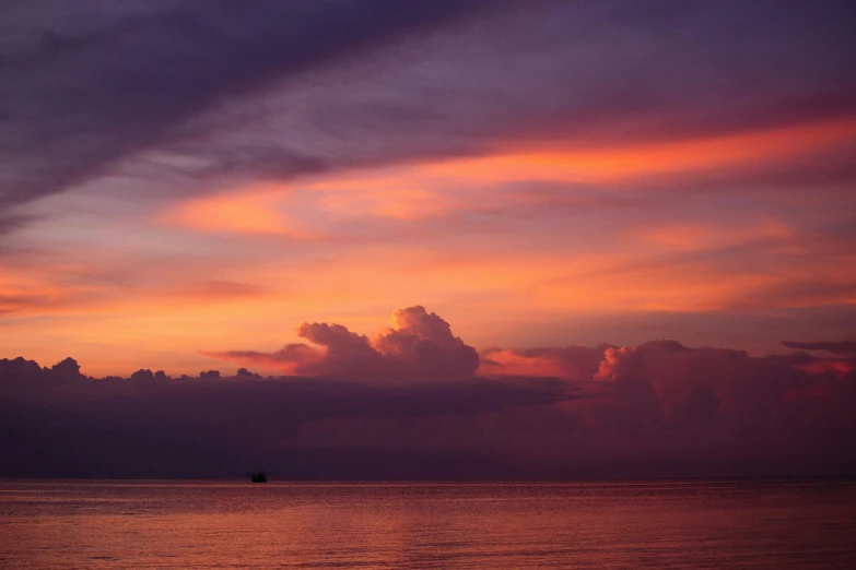 an orange sky hangs over the water at sunset