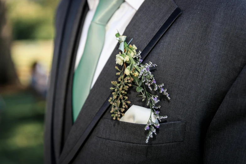 a man in a suit wearing a flower brooch