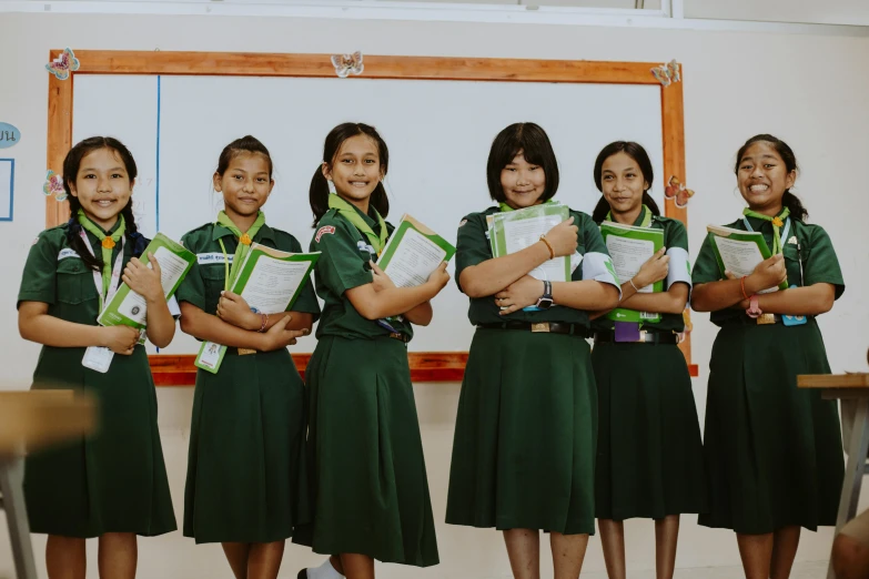 six girls in green uniforms standing together for a picture