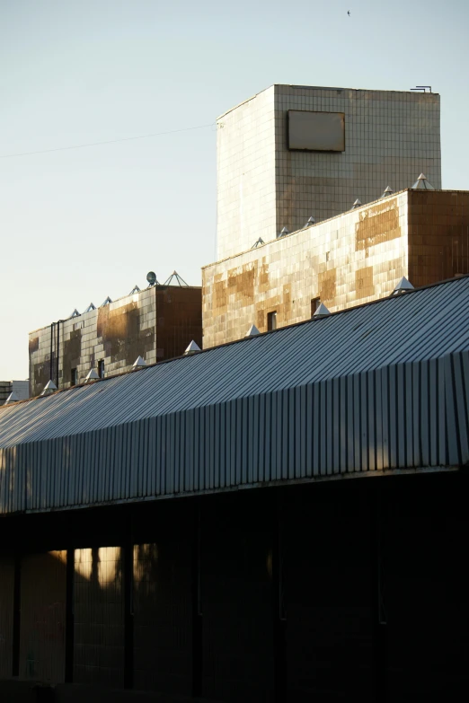 a row of industrial chimneys on the roof of a building