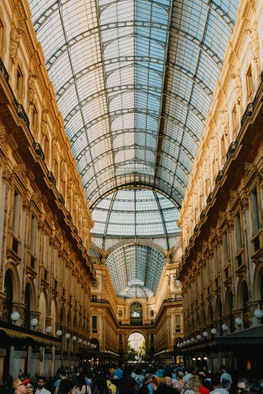 several people are walking down the aisle of an empty shopping mall