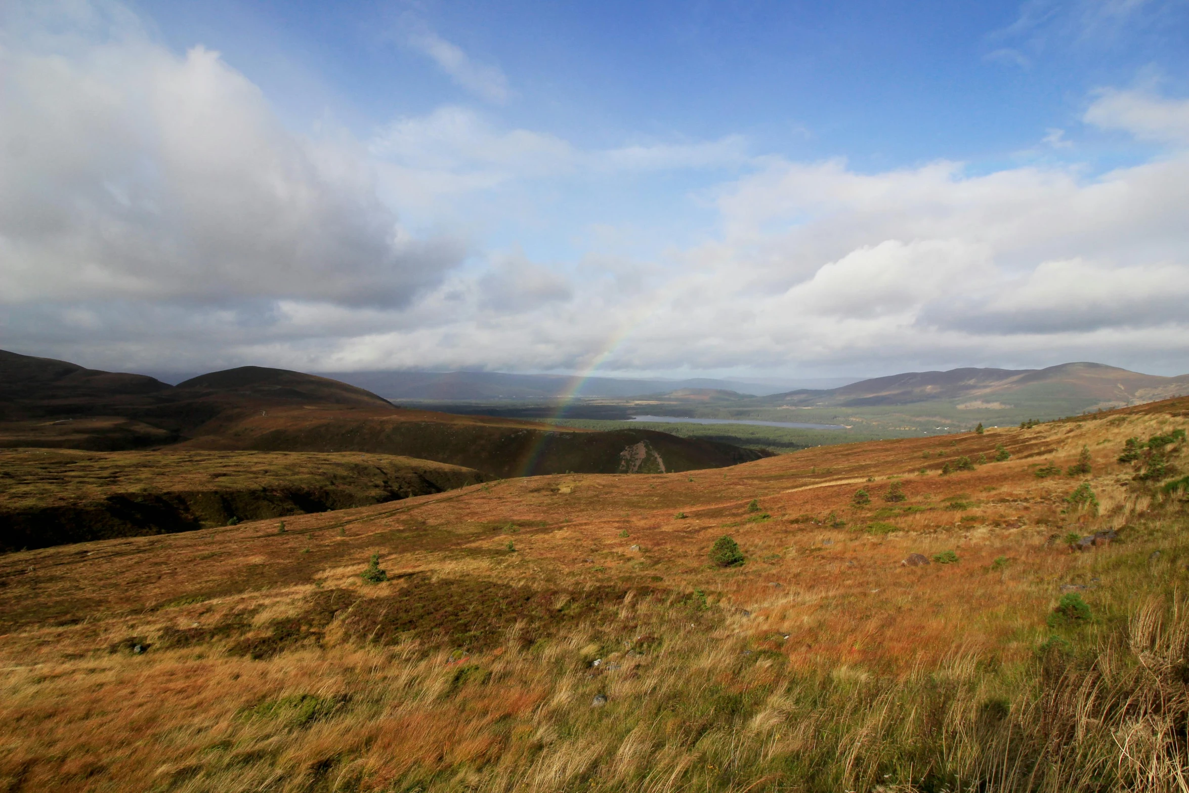 a sunny day with a rainbow in the distance