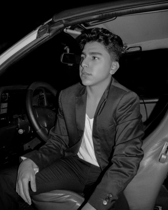 a black and white po of a young man in a car