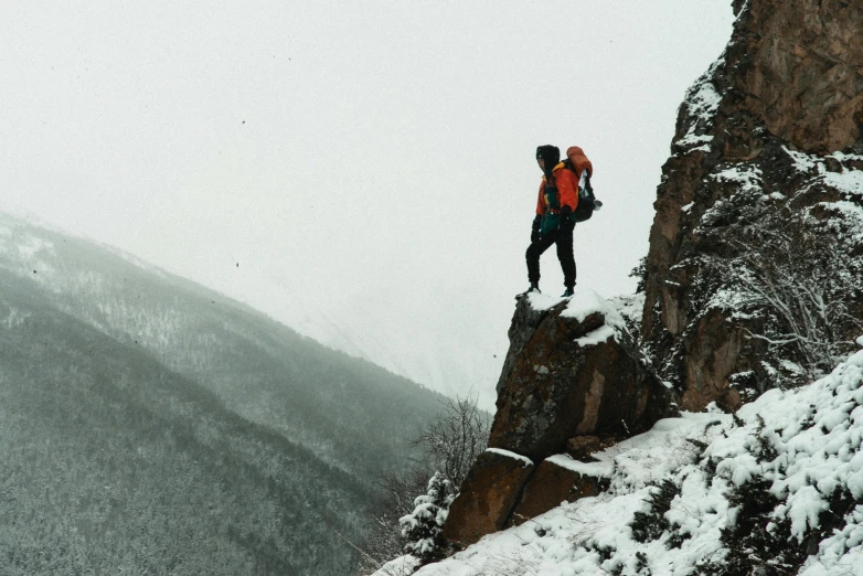 two hikers standing on the edge of a high mountain cliff