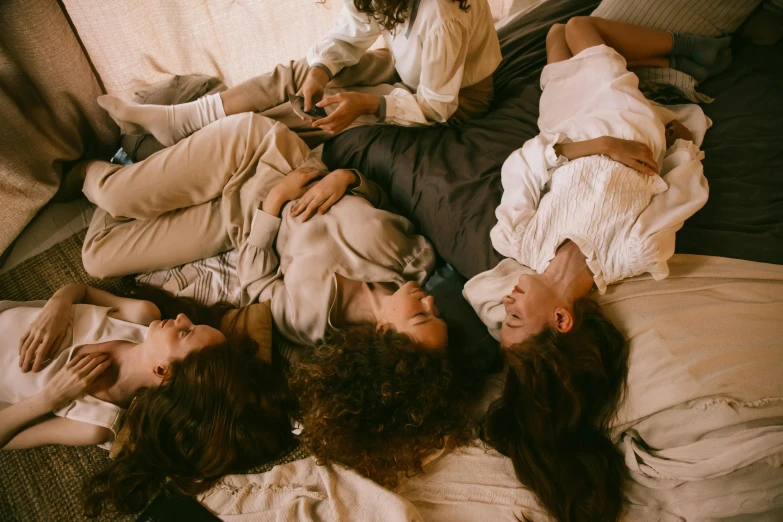 three people in blankets on top of a couch