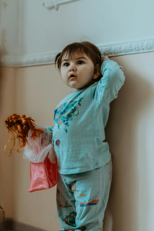 the child is standing in a room holding a bag