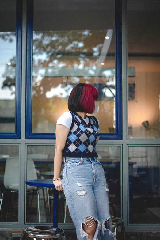 a girl with a punk haircut standing in front of a building