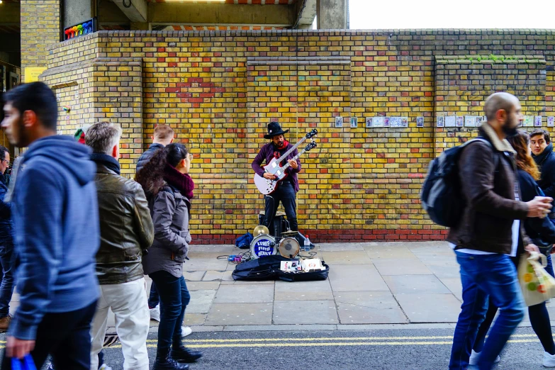 a man playing an electric guitar near people watching