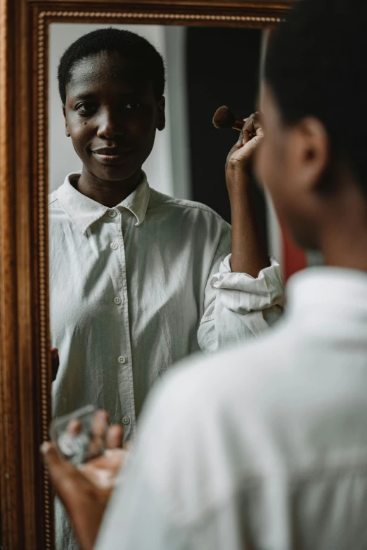 an african american man is looking at his hair in the mirror